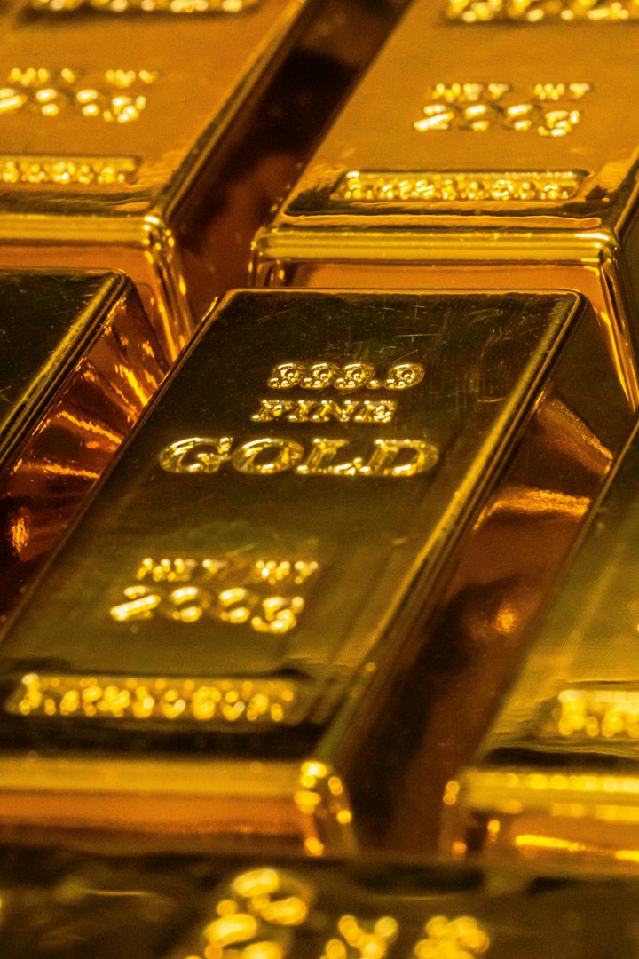 Gold coins on a dark surface — stand-in for XAUt as a Tether tokenized-gold product with issuer controls.